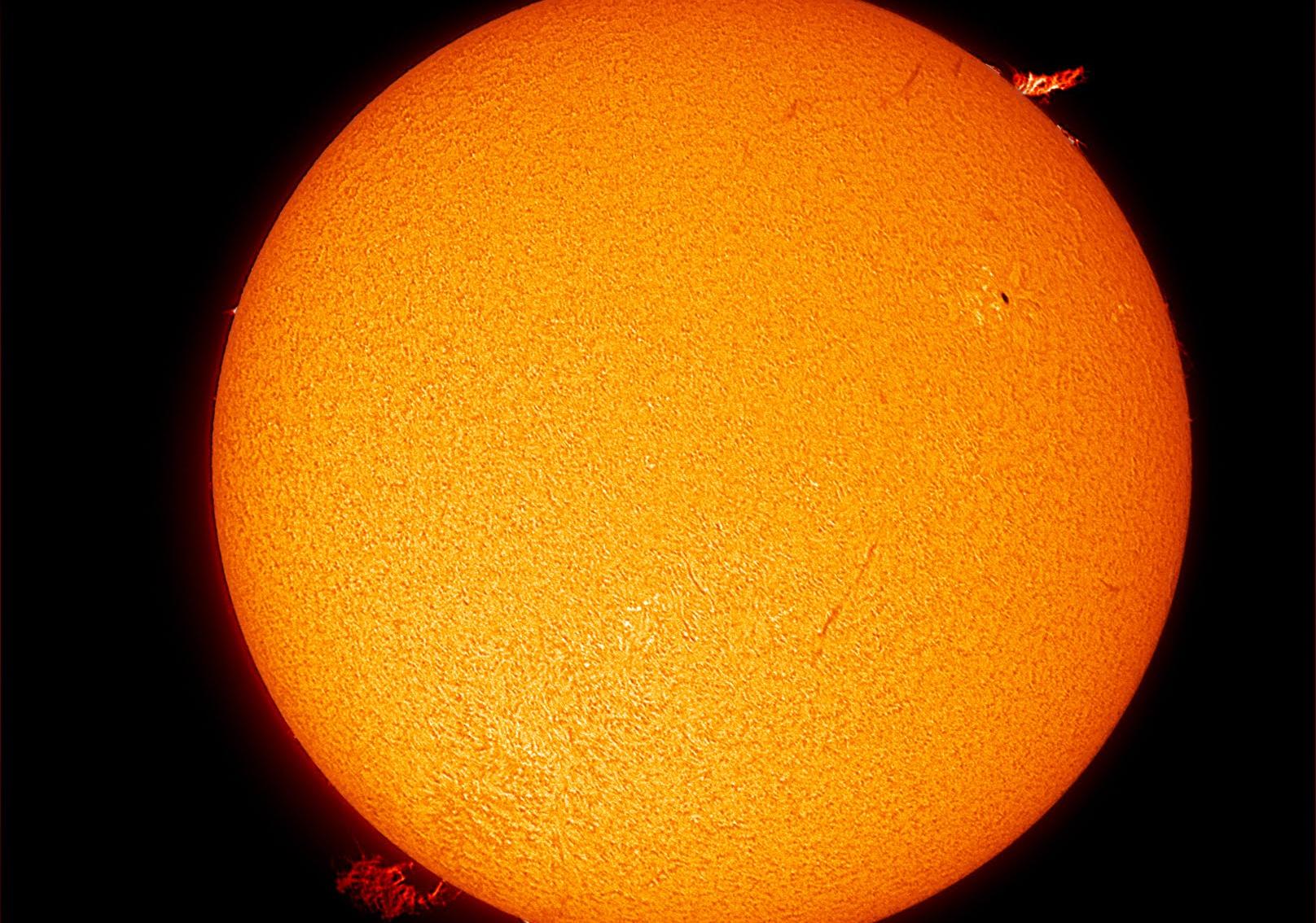 Black and white image of the Sun from the SCSM observatory, with a large sunspot group to the far left.