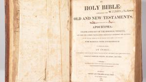 Large open, antique Bible with Title Page Showing includes black lettering and the words "Holy Bible"