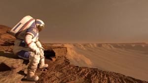 Astronaut sits wearing a white spacesuit with a red, dusty landscape visible behind them