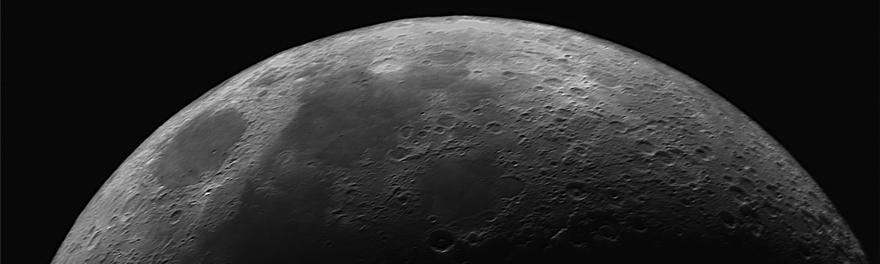 Top half on Moon with visible craters against the blackness of space