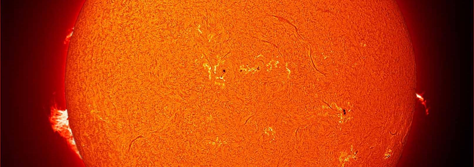 Color image of the Sun from the SCSM observatory, with multiple sunspots and prominences