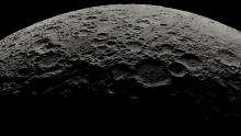 Close up of dark gray cratered surface of the moon 