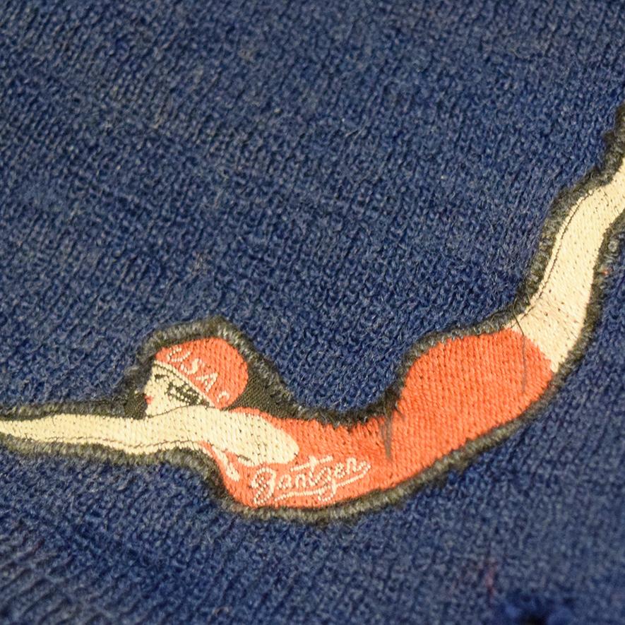 Circa 1920 Jantzen men's wool bathing suit. Blue with a signature logo on their suits, depicting a diving woman in a bright red suit.