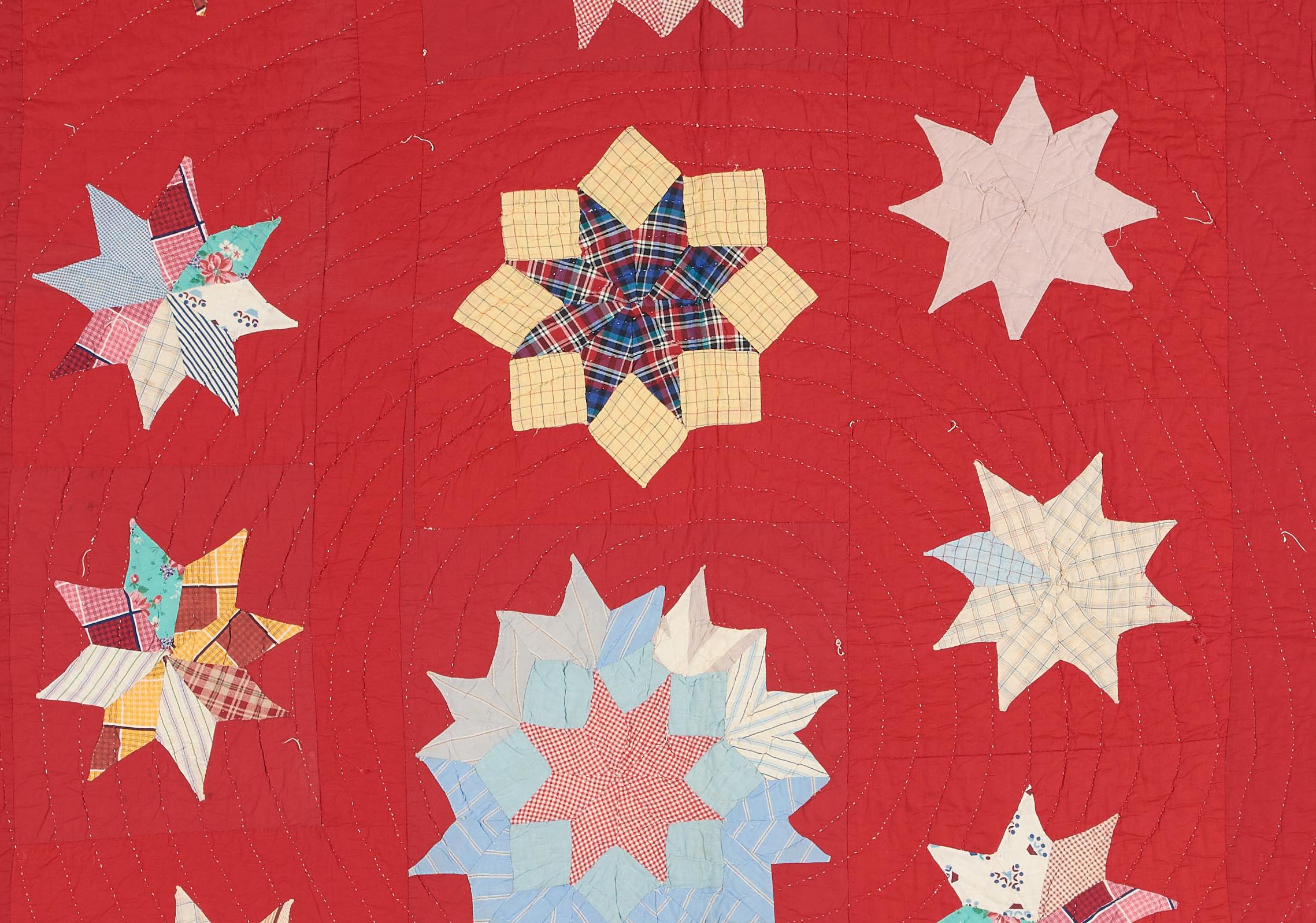 a quilt with multi colored stars on a field of red