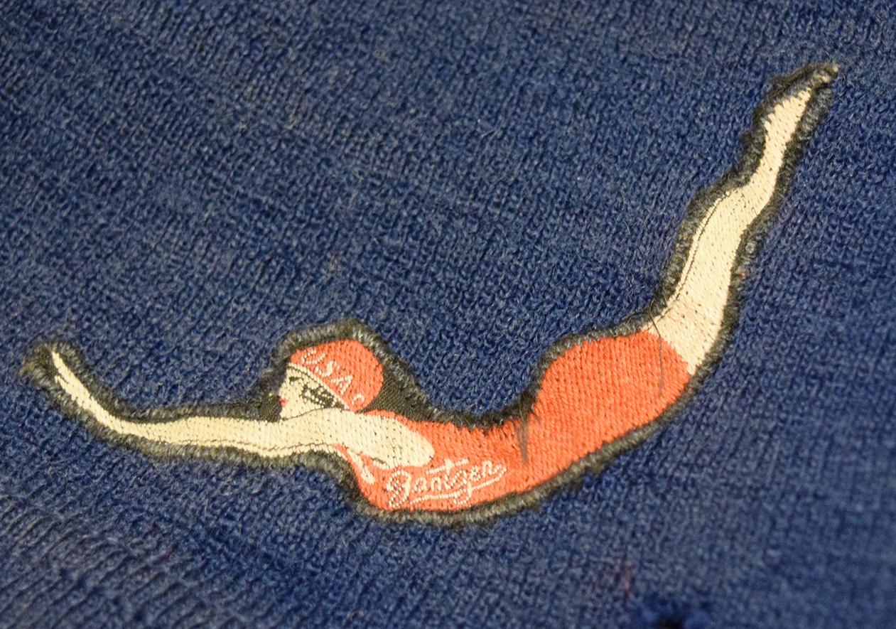 Circa 1920 Jantzen men's wool bathing suit. Blue with a signature logo on their suits, depicting a diving woman in a bright red suit.
