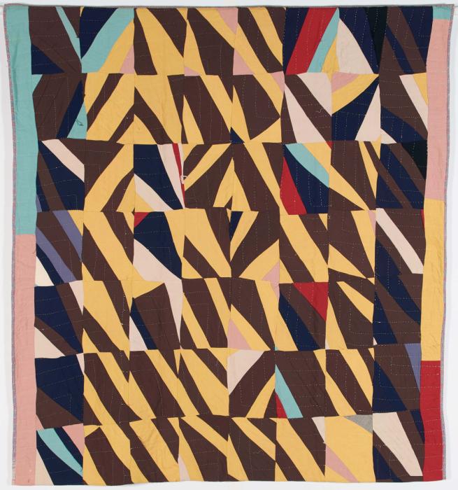 Crazy quilt with pieces yellow, dark brown, light blue, pink and red