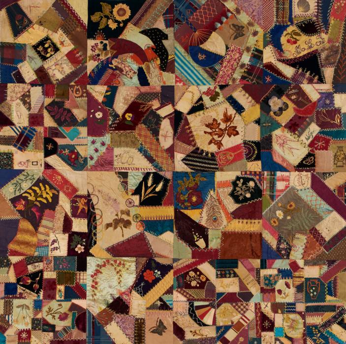 Crazy quilt in a mix of earth tones and variety of fabric types and textures.textures