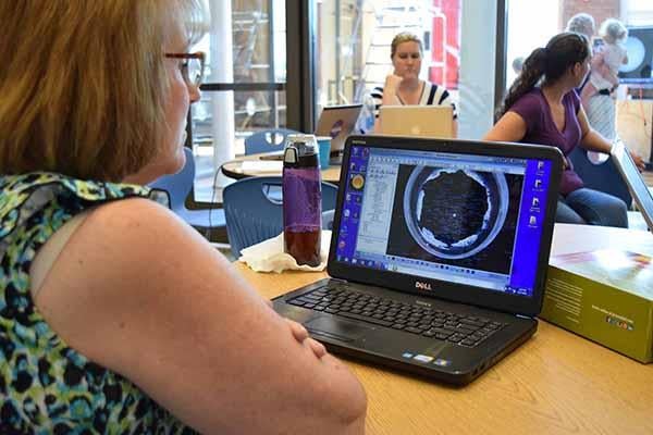 A teacher learns how to connect to the telescope over the Internet. She is seeing the observatory’s control software on her own laptop.