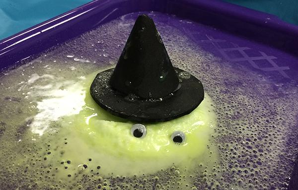 Melting baking soda dough with eyes and a black pointed hat