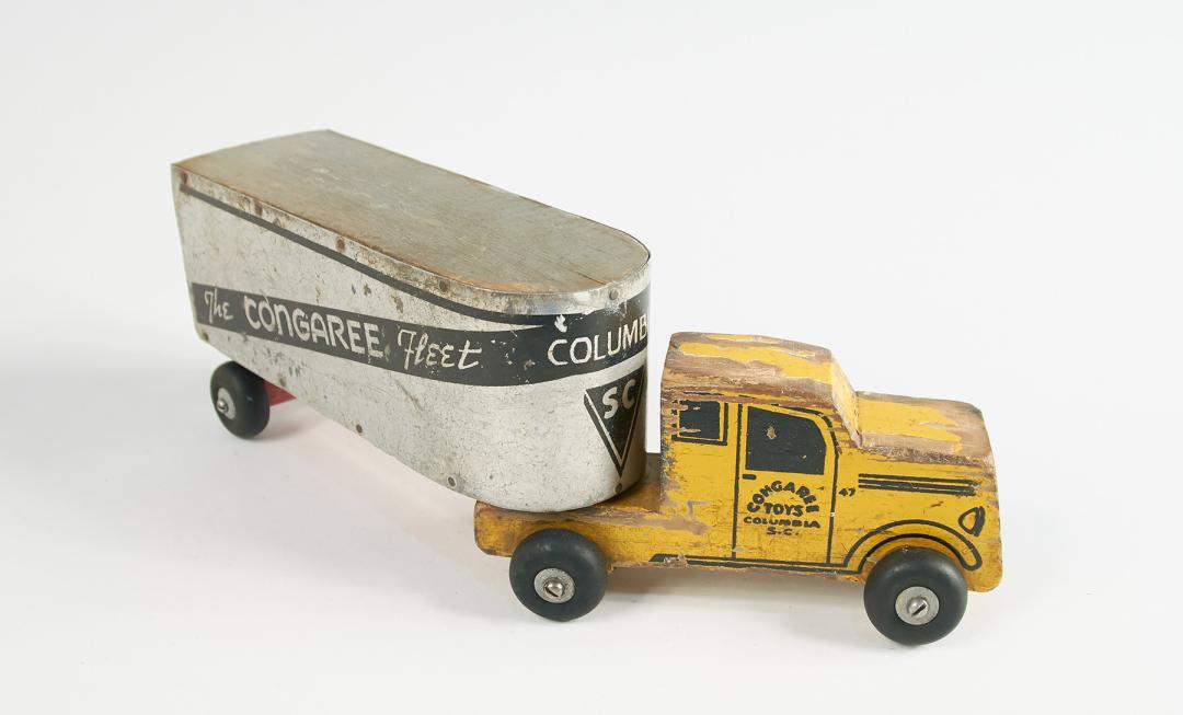 A toy truck with a yellow can and a trailer that says Congaree Fleet
